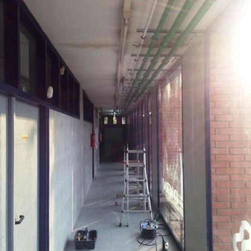 Imagen de tubos de fontanería en techo y paredes de local en obras