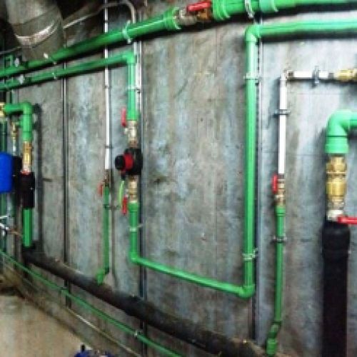 Imagen de tubos de fontanería en techo y paredes de sótano